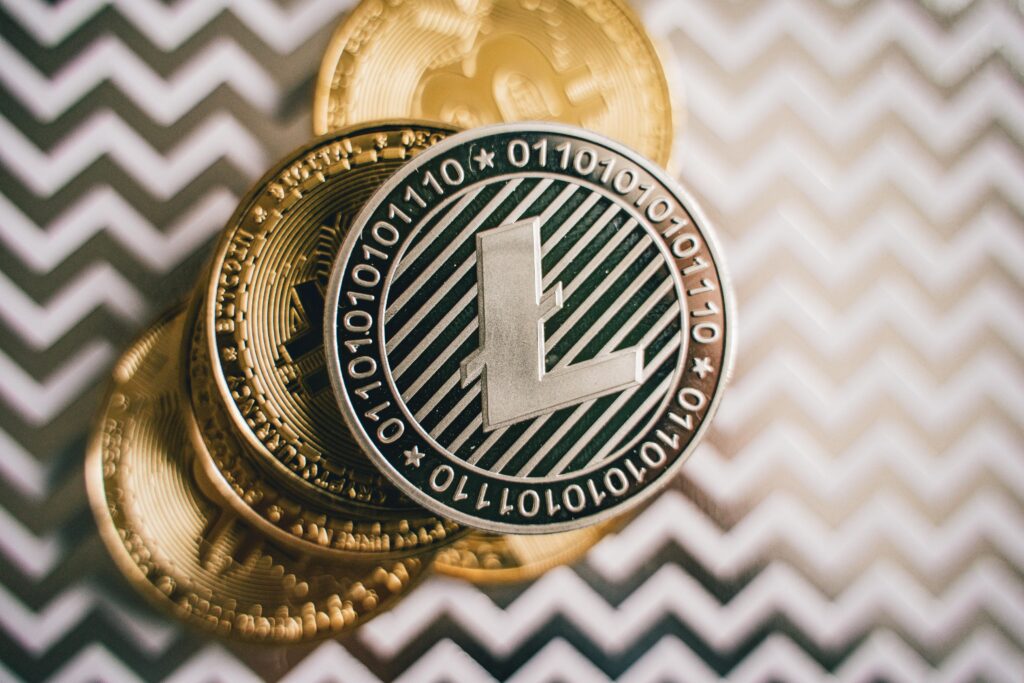 Close-up of Litecoin and Bitcoin coins on a chevron background, symbolizing cryptocurrency and modern finance.